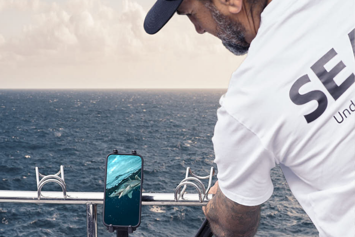 Fishing camera mounted on an extension pole, showing live underwater footage on a phone via Seavu kit
