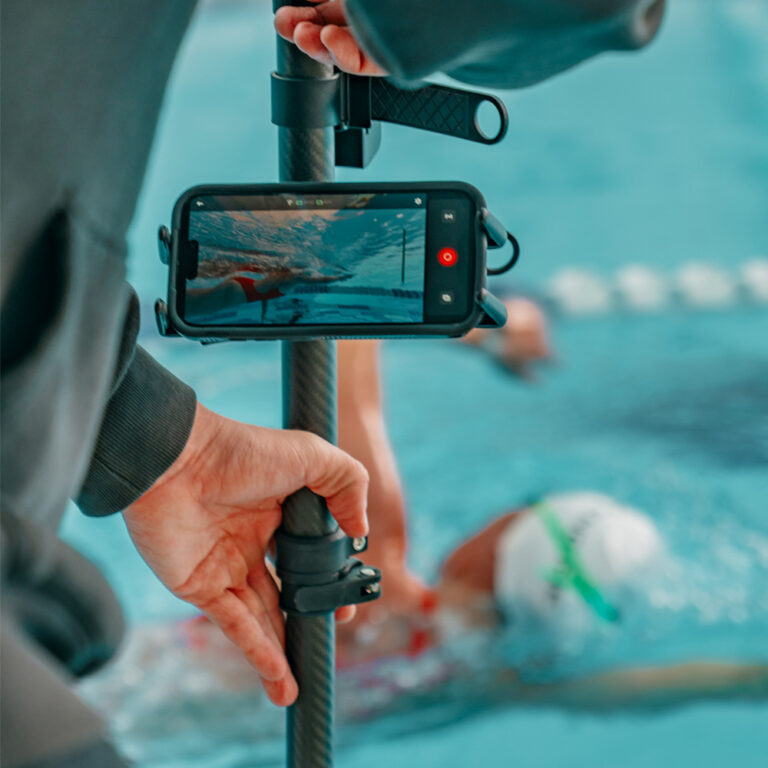 Close up of the Seeker Pole Kit showing live underwater swim footage on a phone while coaching from the pool edge
