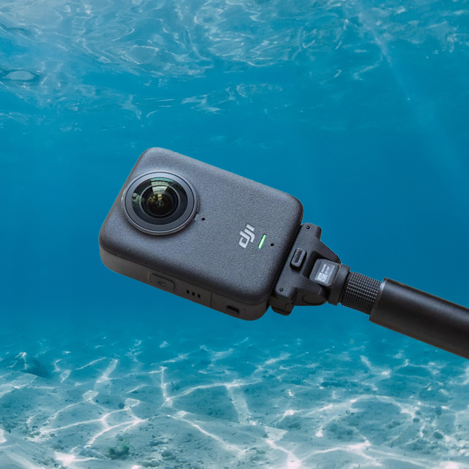 DJI Osmo 360 mounted on a stick underwater, capturing immersive 360-degree footage with low-light clarity