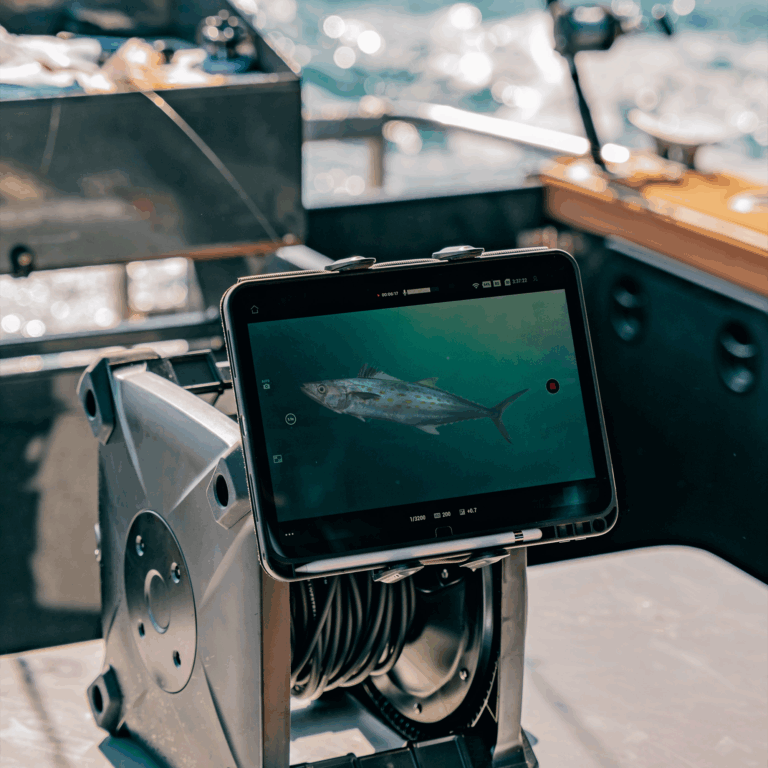 Tablet on a boat showing live underwater footage of a fish using Seavu underwater camera system