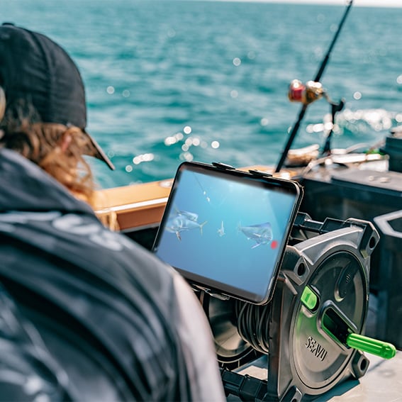Person viewing live underwater footage of fish on a tablet using a Seavu system — CamDo underwater WiFi cable upgrade alternative.