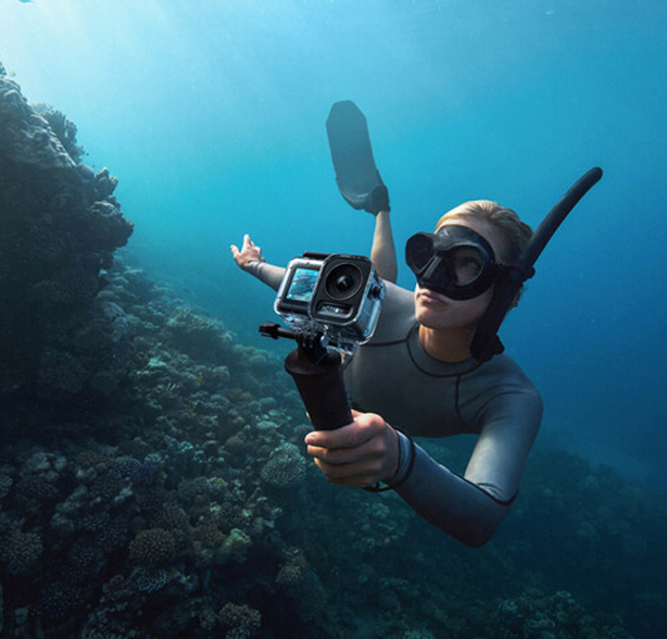 Woman underwater filming with the DJI Osmo Action 5 Pro, one of the best underwater cameras compatible with Seavu kits.
