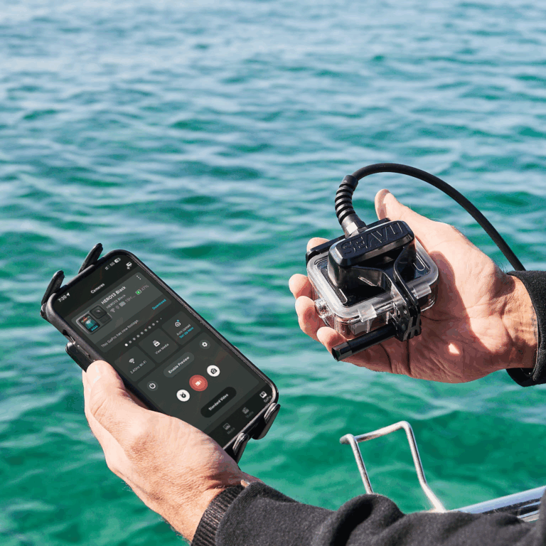 Person holding Seavu Seeker Marine Kit connected to an action camera and phone showing a live underwater feed