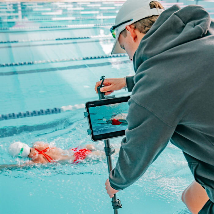 Swim coach using the Seeker Pole Kit to view live underwater footage of a swimmer from the pool edge
